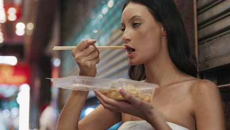 woman eating noodles in a night market