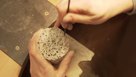 Making-holes-in-concrete-cylinder-with-rounded-file---close-up-shot-in-slow-motion