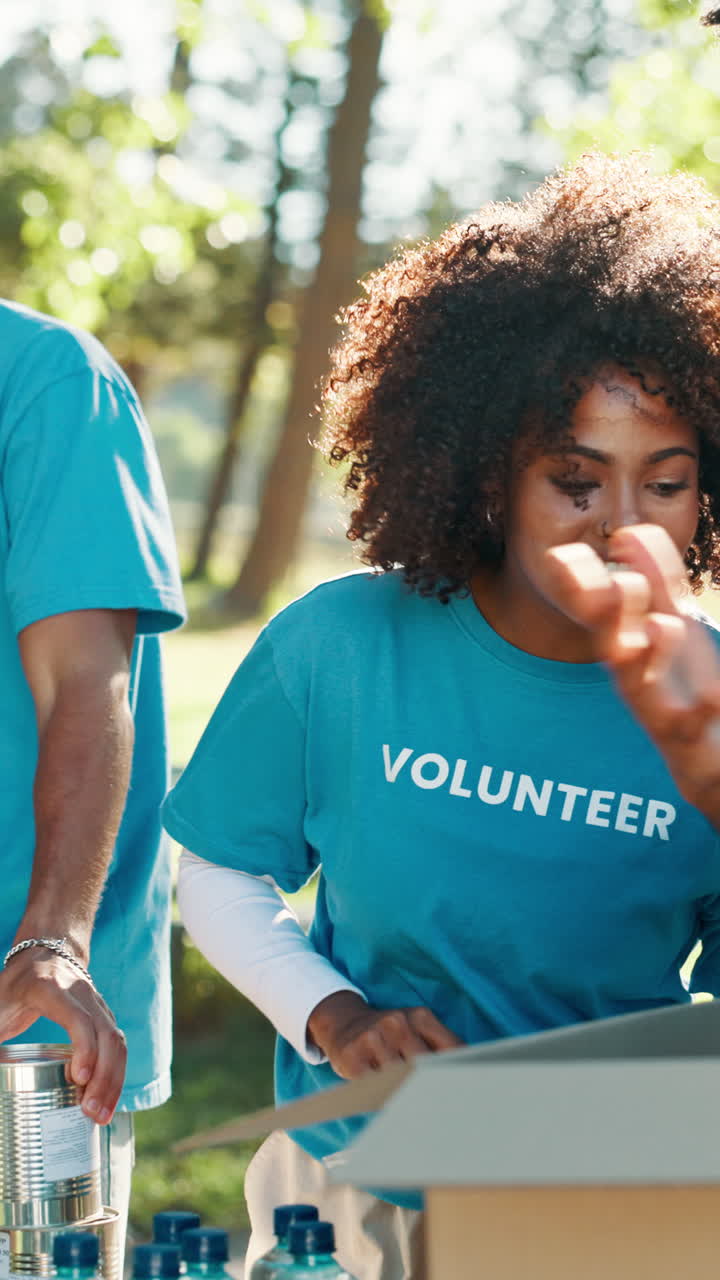 Happy Young Volunteers Sorting Donations Outdoors