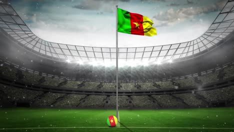 Animation-of-snow-falling-over-flag-of-cameroon-at-sports-stadium