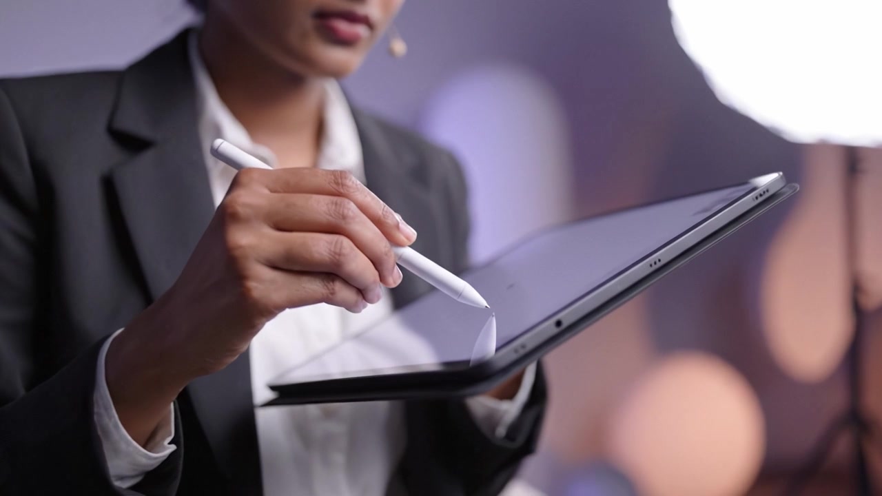 Professionista impegnato che presenta idee innovative attraverso la tecnologia digitale in un moderno ambiente aziendale, con focus sull'interazione tra tablet e stilo.
