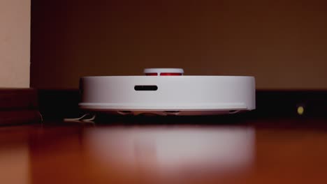 robot aspirador inteligente con lidar en el suelo de madera. robot aspirador realiza la limpieza automática del apartamento. 4k cámara lenta 100 fps, prores 422, 10 bits
