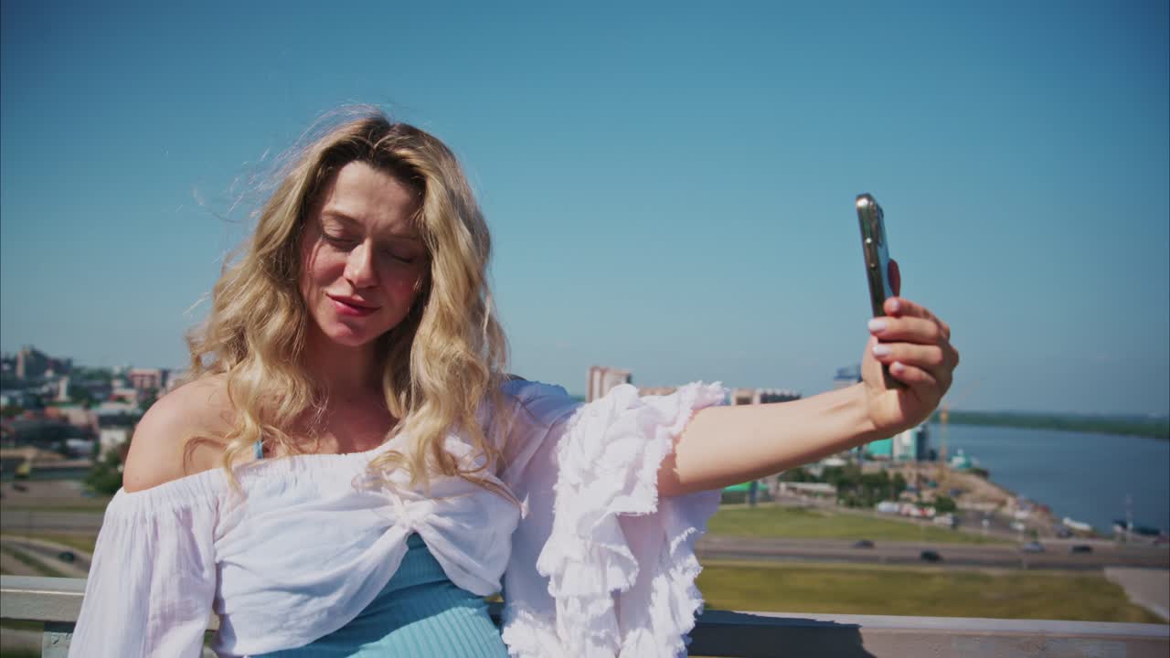 Donna incinta felice che si fa un selfie con la città e il fiume sullo sfondo