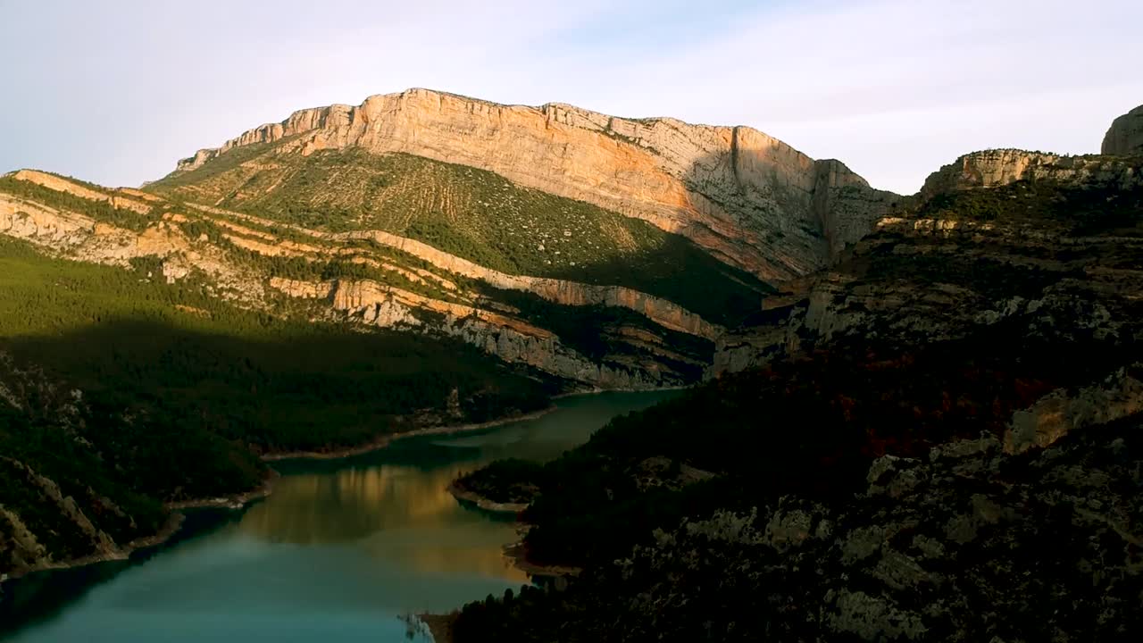 agua que fluye entre dos cordilleras, cubierta de vegetación verde al pie de las cordilleras de barcelona