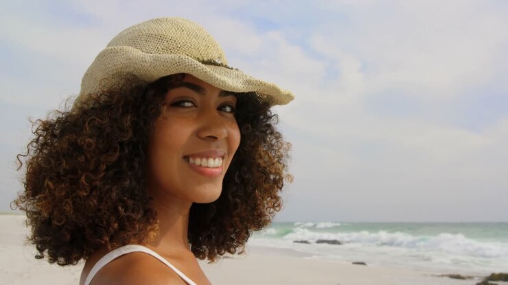 Vista laterale di donna afroamericana in piedi in spiaggia 4k