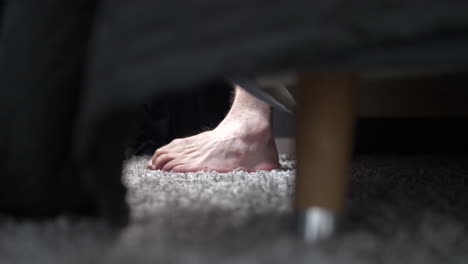 close-up of a man's caucasian feet getting out of bed