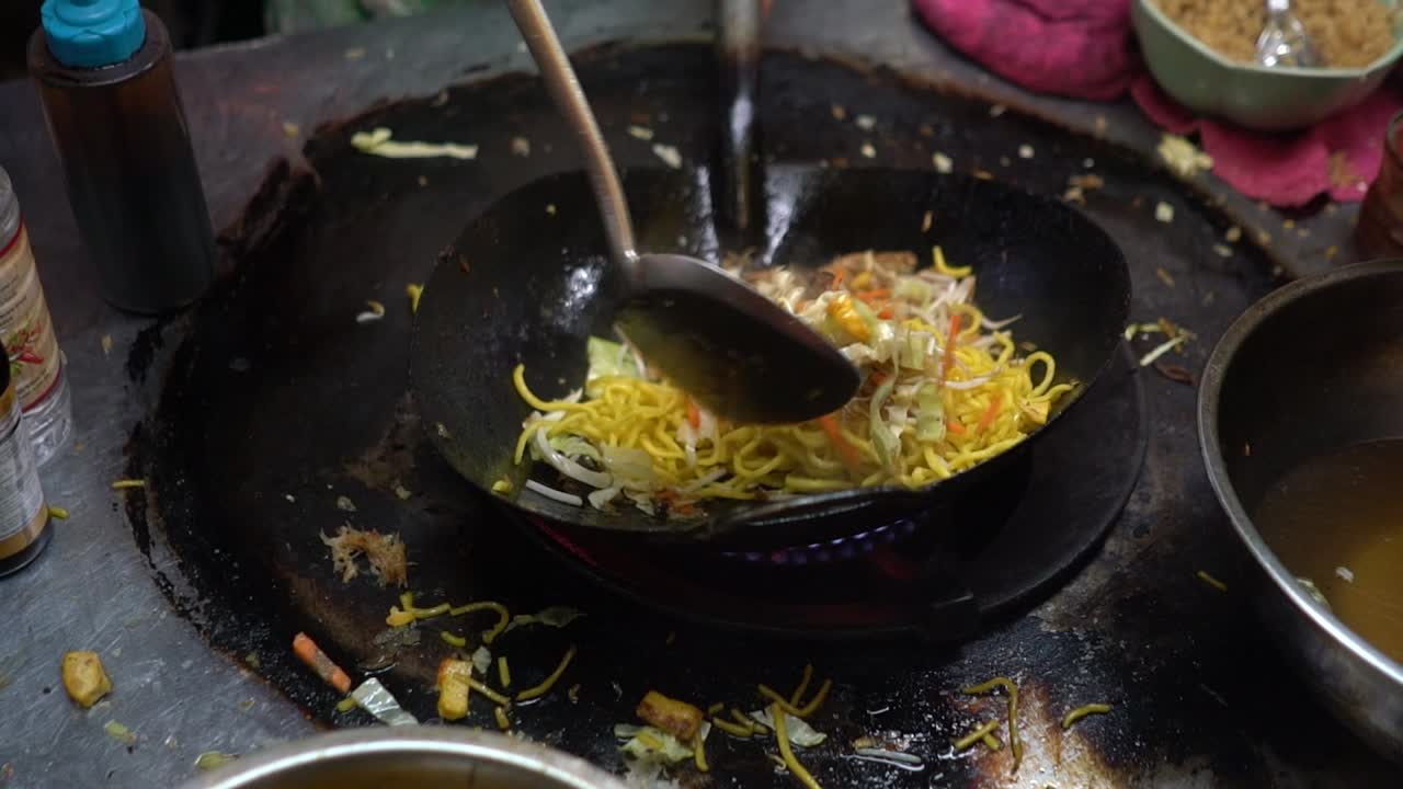 Cucinare noodles con verdure su un fornello disordinato a Chinatown, Bangkok, Thailandia - primo piano