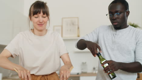 hombre y mujer multiétnicos cocinando ensalada en la cocina