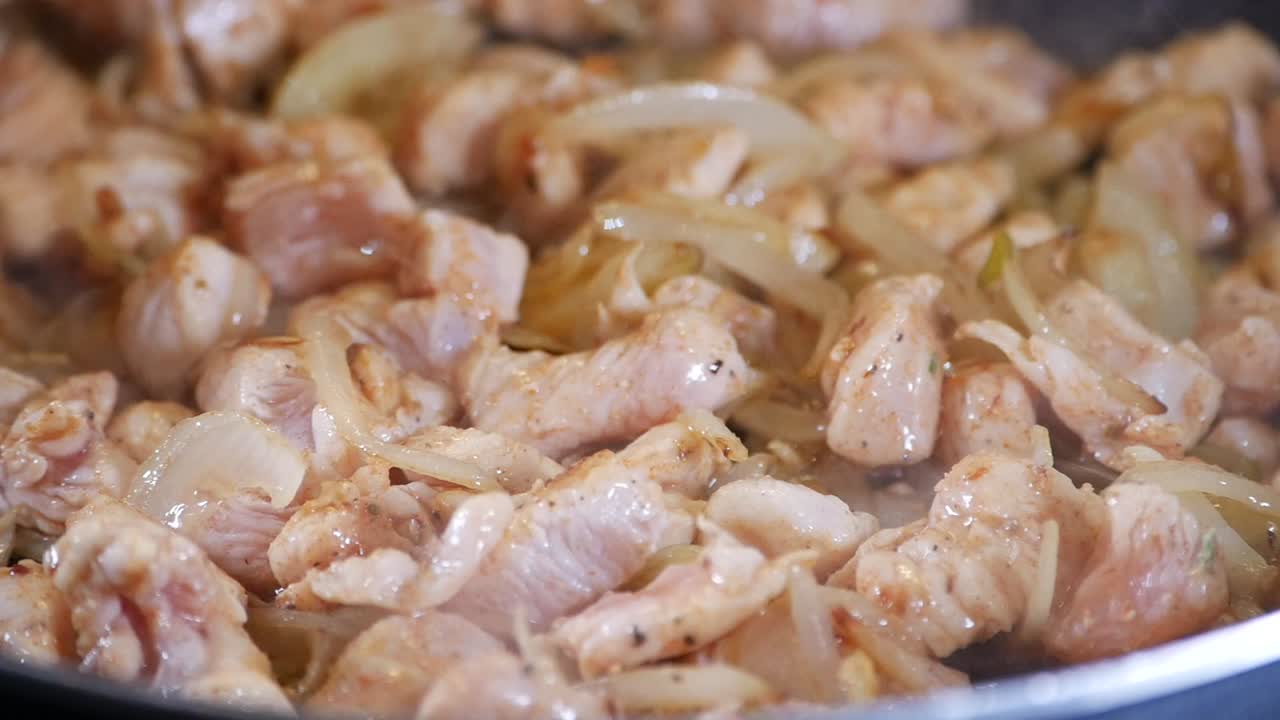 Pollo e cipolle saltati che friggono in padella