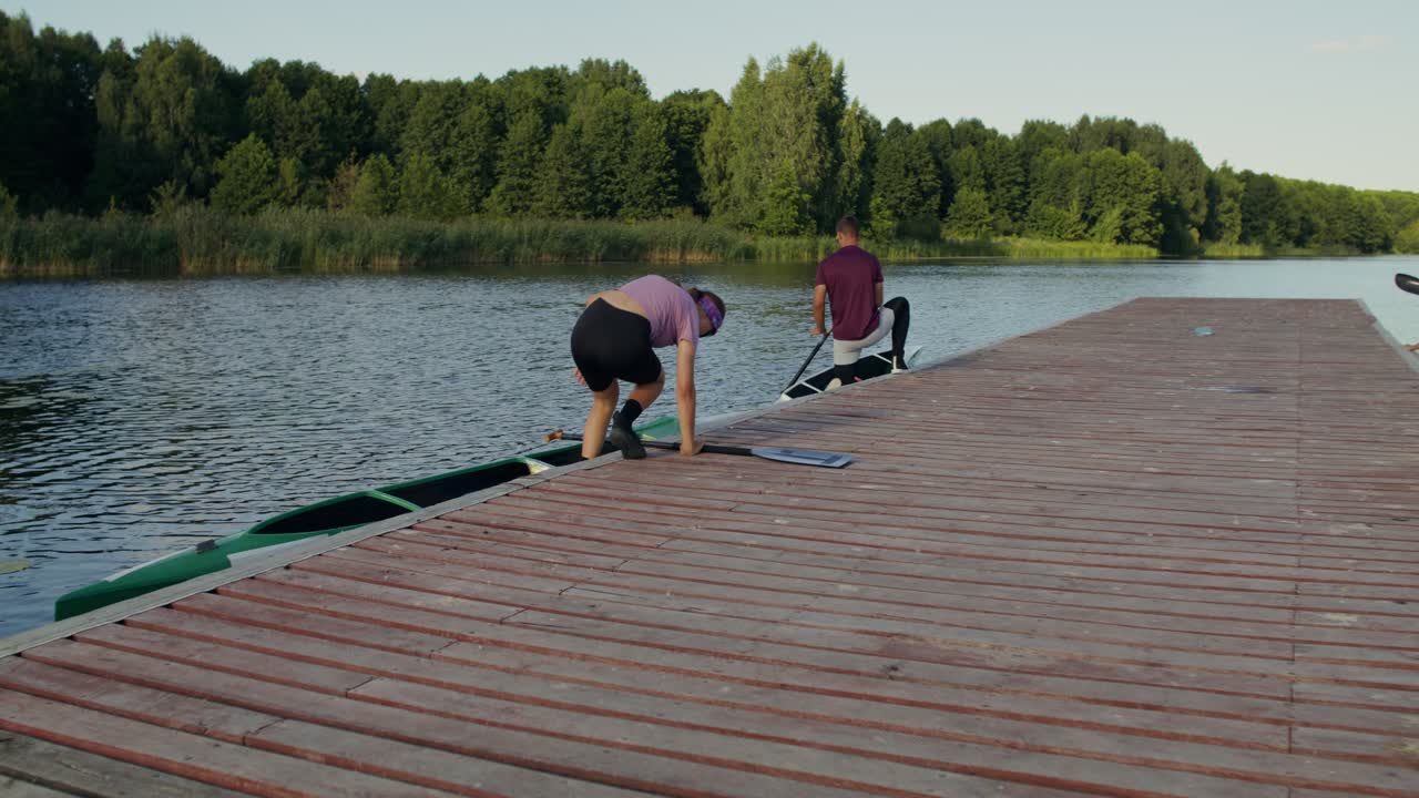 Folk der forbereder sig til kajakroning ved en søbred.
