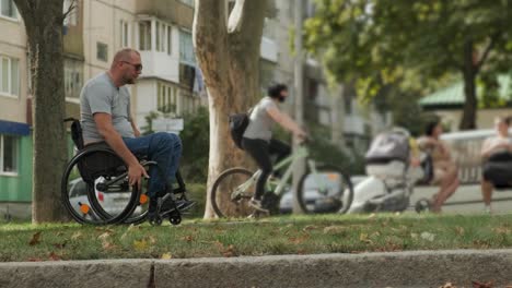 man with disabilities in wheelchair walk at the park alley