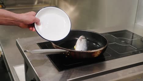 a fish in a pan being cooked