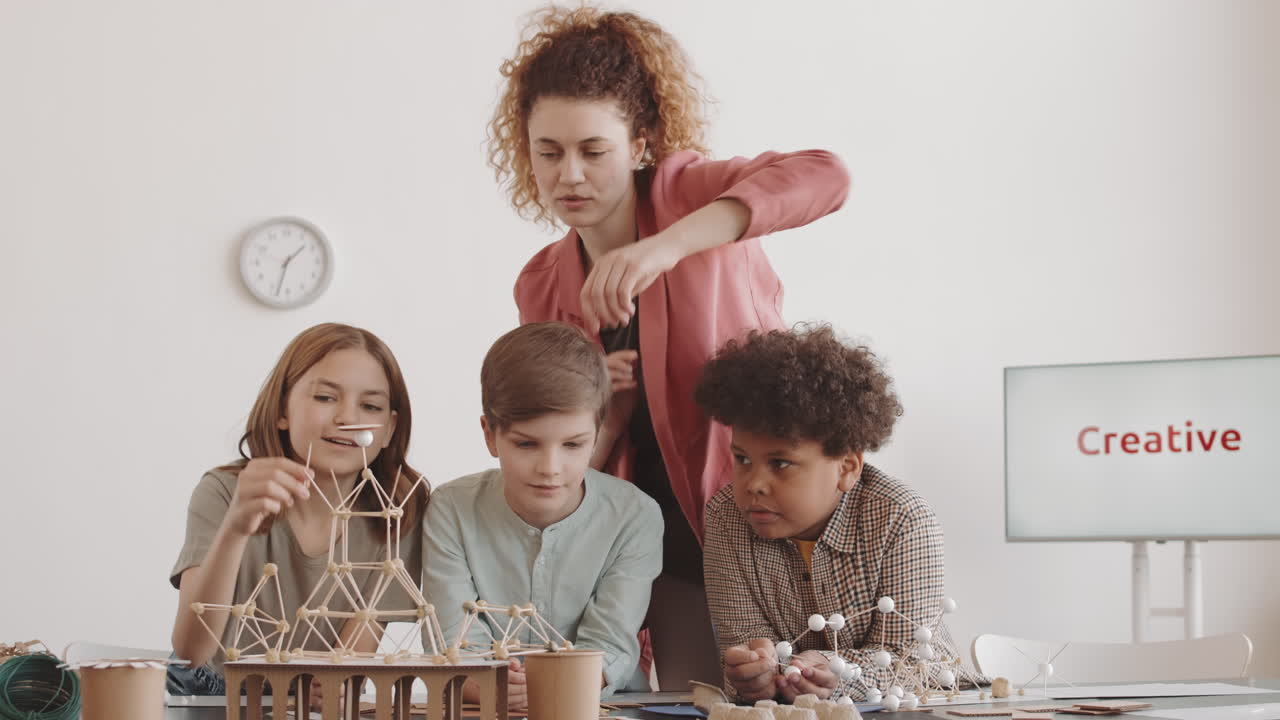 Teacher Helping Kids Assemble Miniature Model