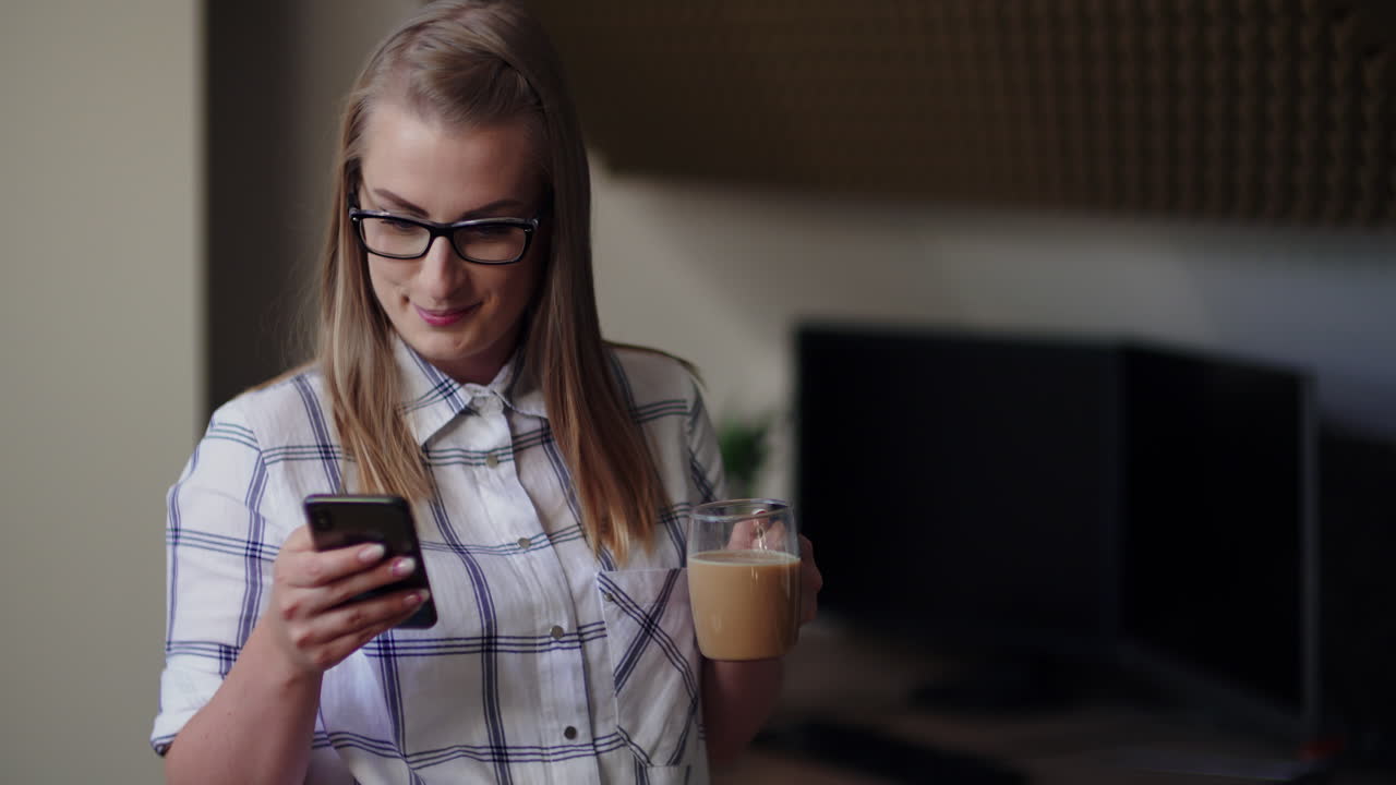 mujer de negocios tomando café mientras usa el teléfono