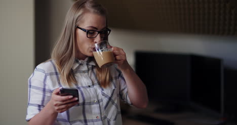 mujer de negocios tomando café mientras usa el teléfono