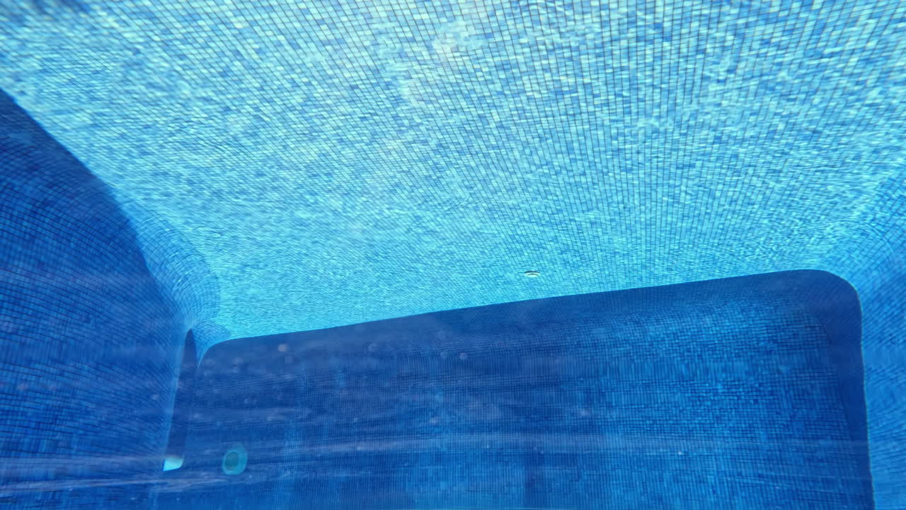 Undervandsudsigt i swimmingpool med blå fliser