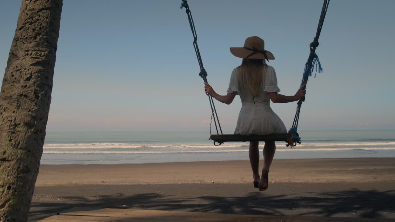 mujer balanceándose en una playa