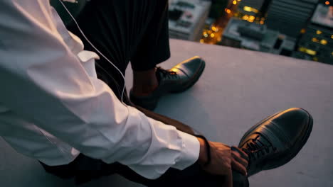 businessman relaxing on rooftop at sunset