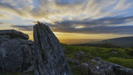 timelapse of rural nature landscape with ruins of prehistoric passage tomb in the foreground during dramatic sunset viewed from carrowkeel in county sligo in ireland