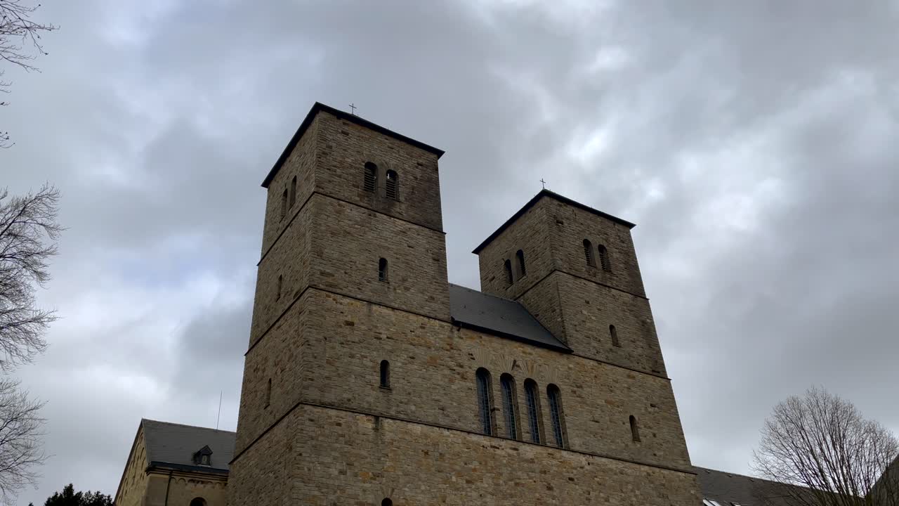 Blick von unten auf das Benediktinerkloster Gerleve an einem bewölkten Tag.
