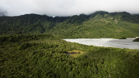 fotografía aérea de un lago rodeado de vastas montañas en nueva zelanda