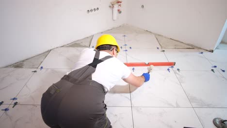 a professional tiler works with a water level