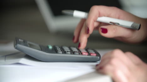 businesswoman calculating losses in office