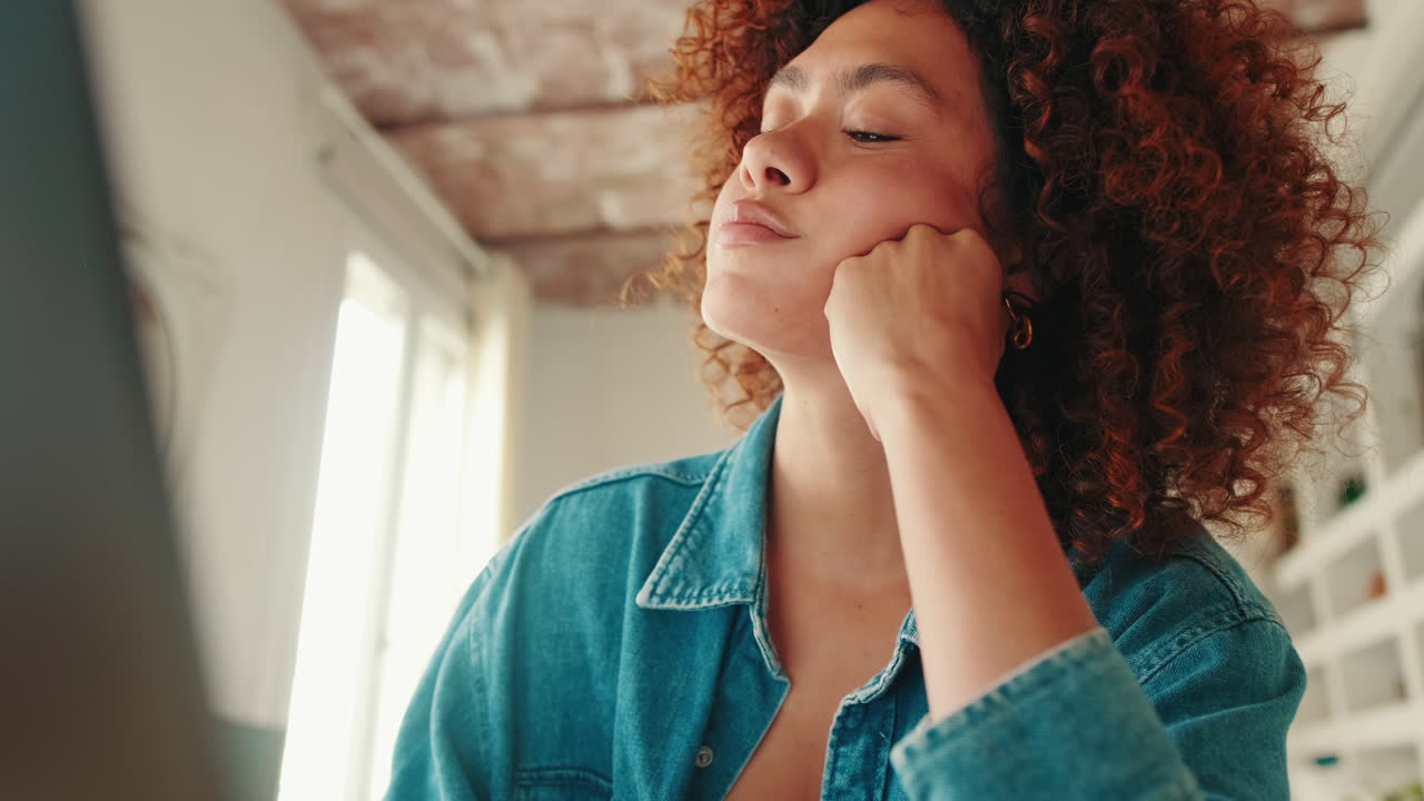 Thoughtful Young Woman with Curly Hair Looking Up and Smiling
