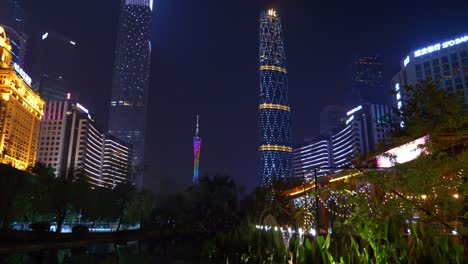 night illuminated guangzhou city downtown megatalls buildings pond reflection panorama 4k