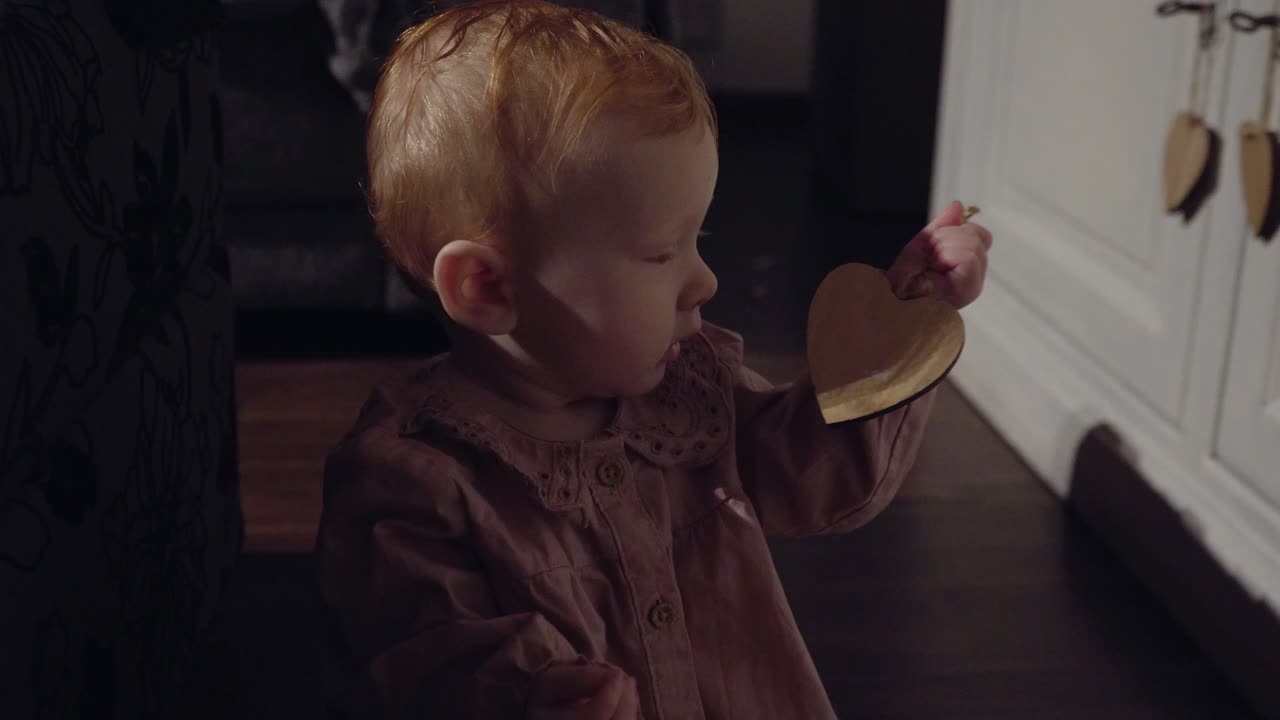 Little baby playing with a wooden hart