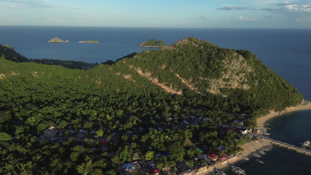 Cảnh nhìn từ máy bay không người lái trên cao về những ngọn núi xanh tươi bao phủ đảo Guimaras, Philippines. Phong cảnh nhiệt đới hẻo lánh với thảm thực vật dày đặc và một vài ngôi nhà nhỏ được bao quanh bởi thiên nhiên hoang sơ