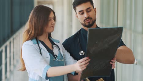 portrait of a doctor and a nurse looking at an x-ray of the head