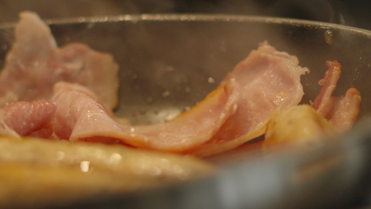 Tasty Bacon Slices in Pan with Hot Steam Rising in Slow Motion. Cooking Breakfast Morning Food Footage.