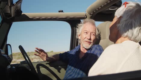 senior couple talking in a car at the beach