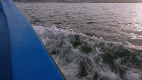 splashing water at the side of a traveling boat at sunset