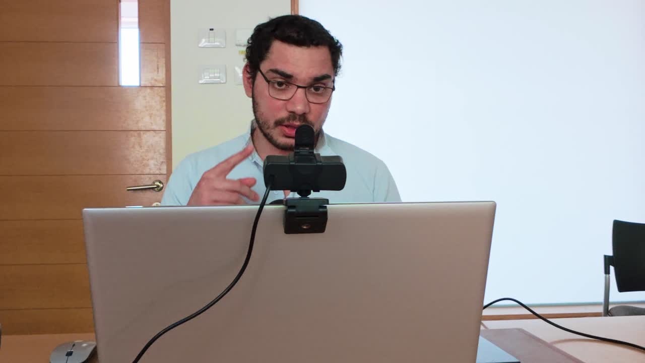 Young Man Presenting to Colleagues Remotely