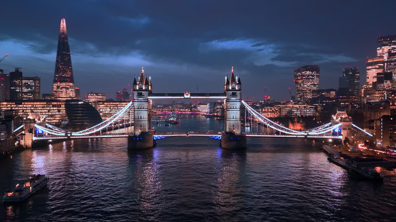 Boat drifts towards Tower Bridge glowing in London’s evening light