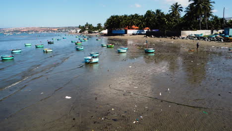 Round-traditional-Vietnamese-coracle-boats-float-on-dirty-polluted-beach-shore