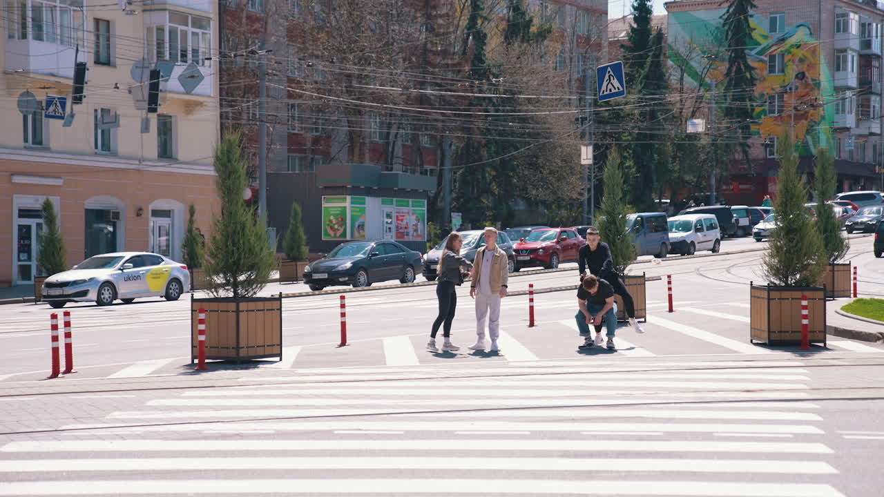 Hipster young people doing tricks in the city street. Joyful friends having fun together on the city transport background. Youth culture.