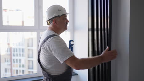 a man plumber checks the batteries and heating system. heating season