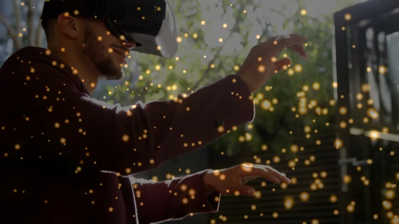 Man wearing VR headset bringing hands forward, manipulating golden particles, testing tech outdoors