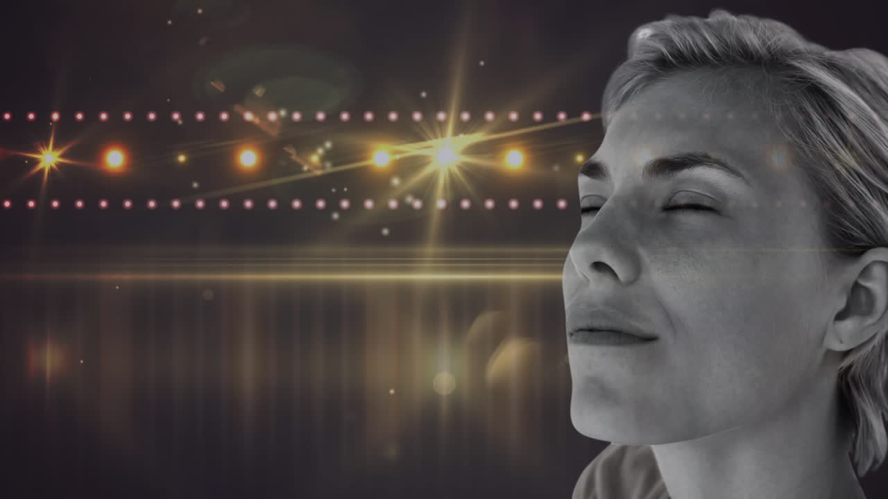 백인 여성 위 에  ⁇ 은 꽃 디자인 이 있으며, 눈 은 배경 에 있는 빛 의 반점 에 대항 하여 닫혀 있다