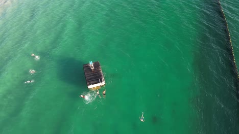 4K-60FPS-Drone-View-of-People-Jumping-from-Platform-in-the-Ocean