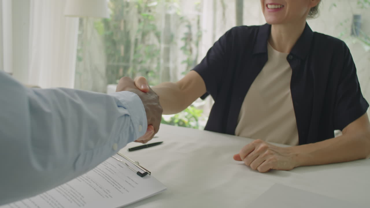 Diverse Man and Woman Shaking Hands after Signing Contract