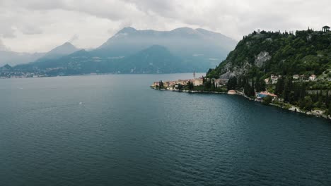 Aerial-view-pulling-away-from-Varenna,-Italy-sitting-on-the-side-of-Lake-Como