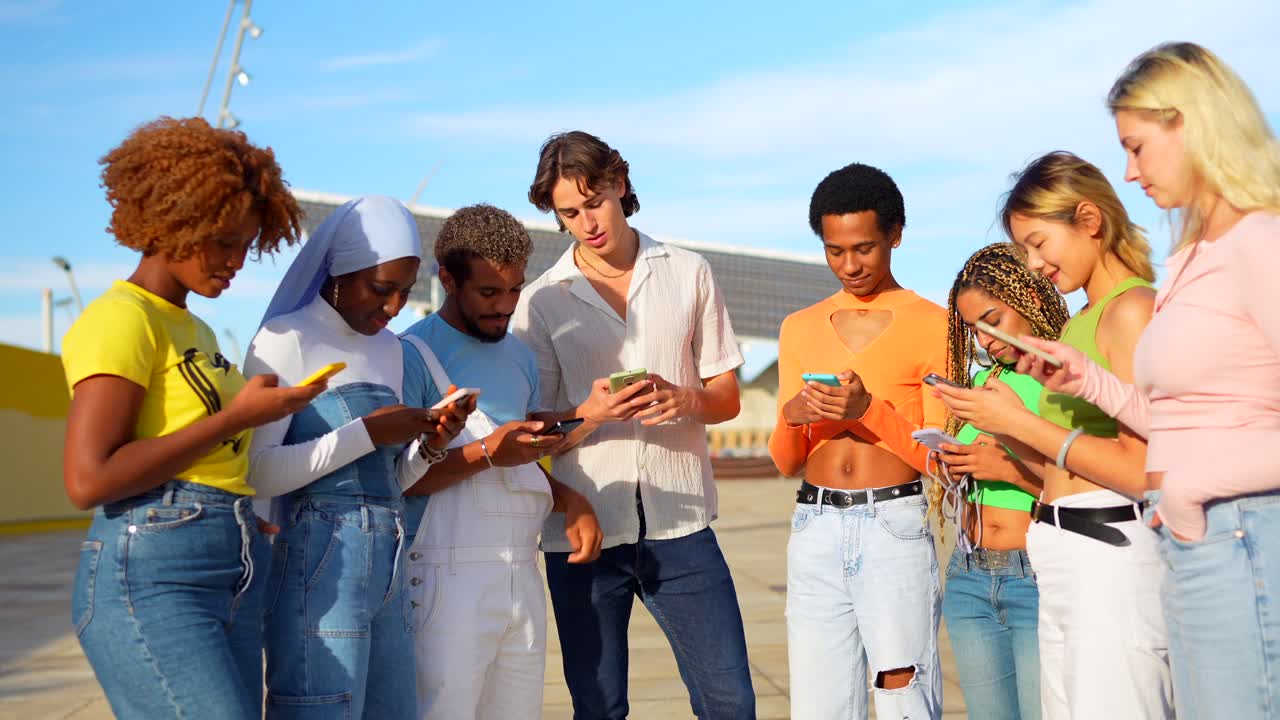 Diverse Group of Young People Using Smartphones Outdoors