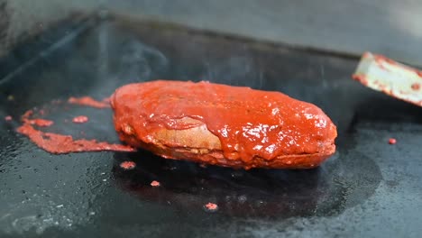 Burger-Bread-being-toasted-with-tomato-sauce,-Vegan-burger-concept