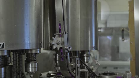 plastic-bottle-caps-unlabelled-moving-on-the-conveyor-system-using-advanced-automated-robotic-machinery-in-a-drinking-water-factory