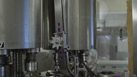 tapas de botellas de plástico no etiquetadas que se mueven en el sistema de transporte utilizando maquinaria robótica automatizada avanzada en una fábrica de agua potable