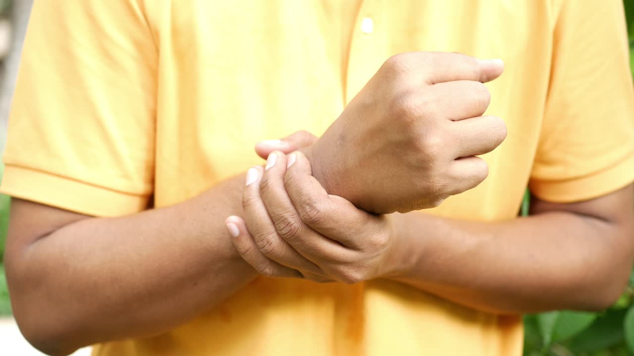 Uomo che si tiene il polso per il dolore